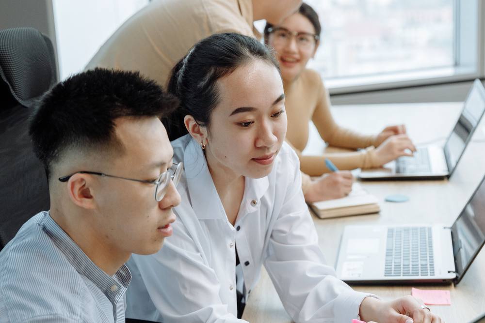 Colleagues collaborating at a laptop